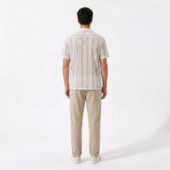 Man wearing a striped shirt and beige pants on a white background