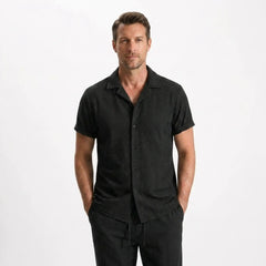 Man wearing a striped shirt and black pants on a white background