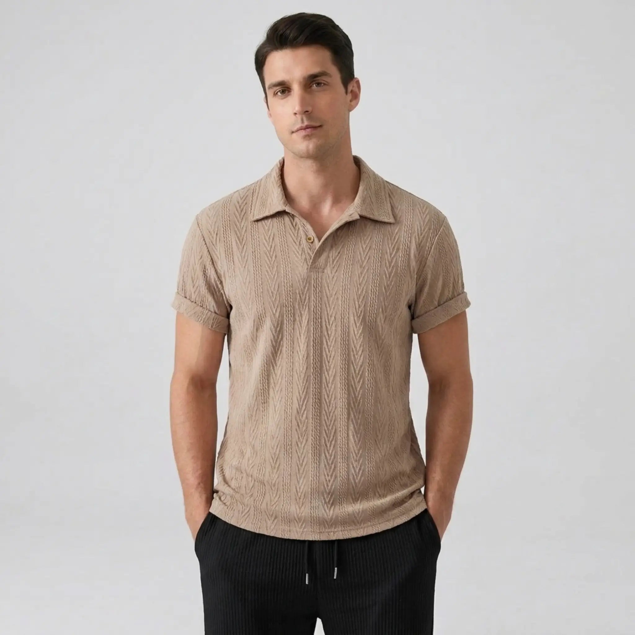 Man wearing a tan knitted polo shirt against a plain background
