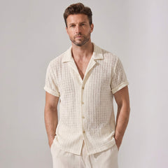 Man wearing a textured white shirt against a plain background