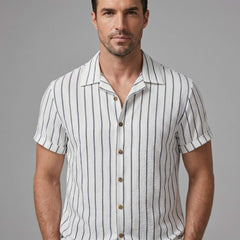 Man wearing a white and gray striped shirt against a gray background