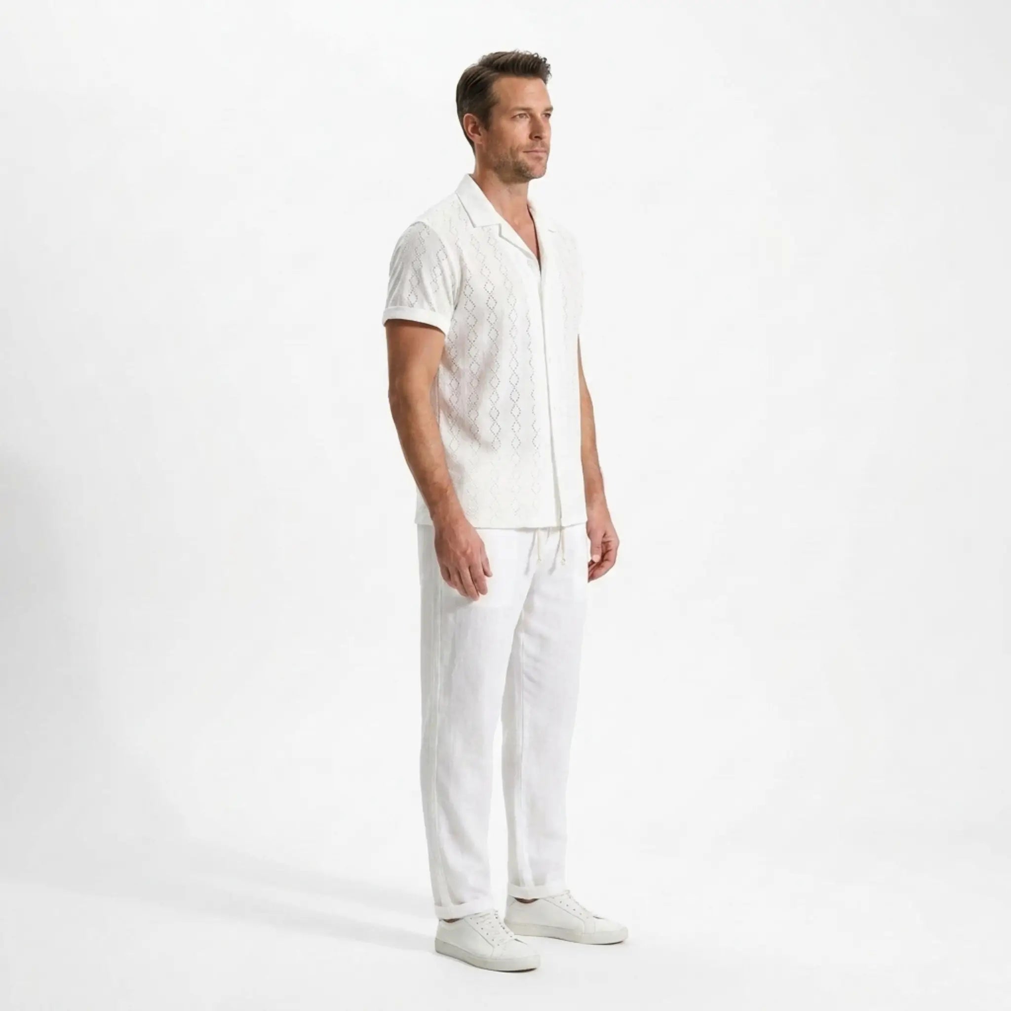 Man wearing a white outfit on a plain background