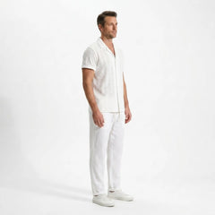 Man wearing a white outfit on a plain background