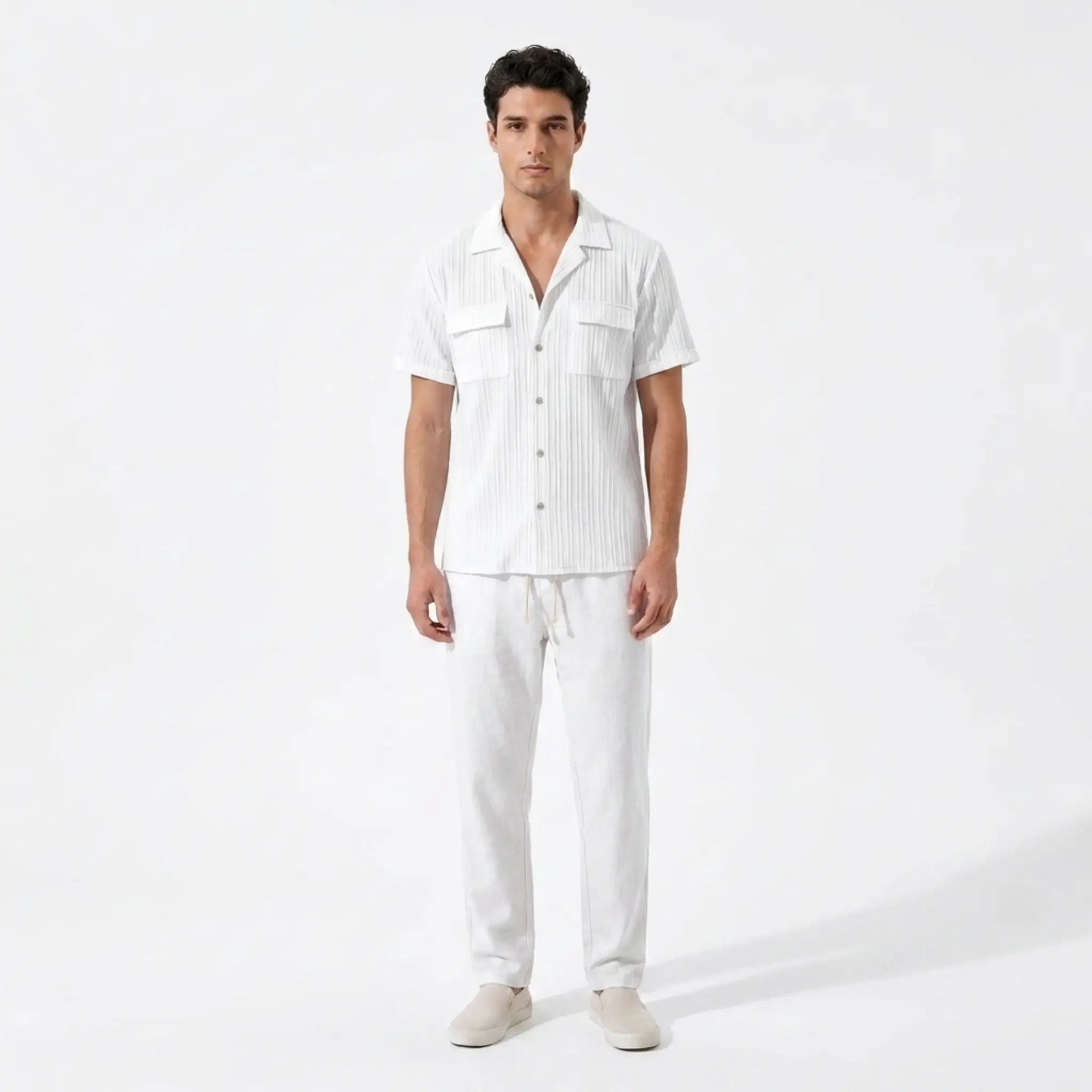 Man wearing a white outfit with a shirt and pants on a white background