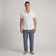 Man wearing a white shirt and blue striped pants on a plain background