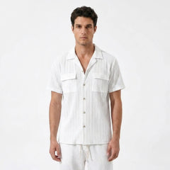 Man wearing a white short-sleeve button-up shirt and pants on a white background