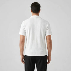 Man wearing a white textured polo shirt and black pants back view on a light gray background