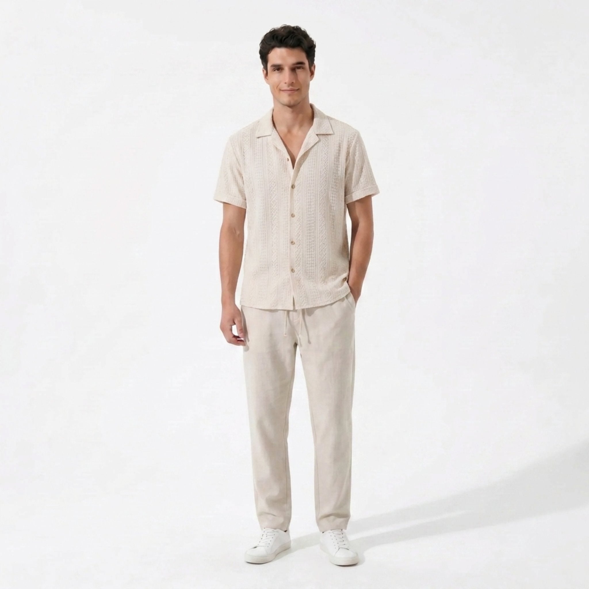 Front view of Man wearing beige geometric jacquard button up shirt and beige linen pants