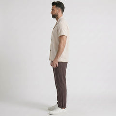 Man wearing a beige shirt and coffee pants on a white background