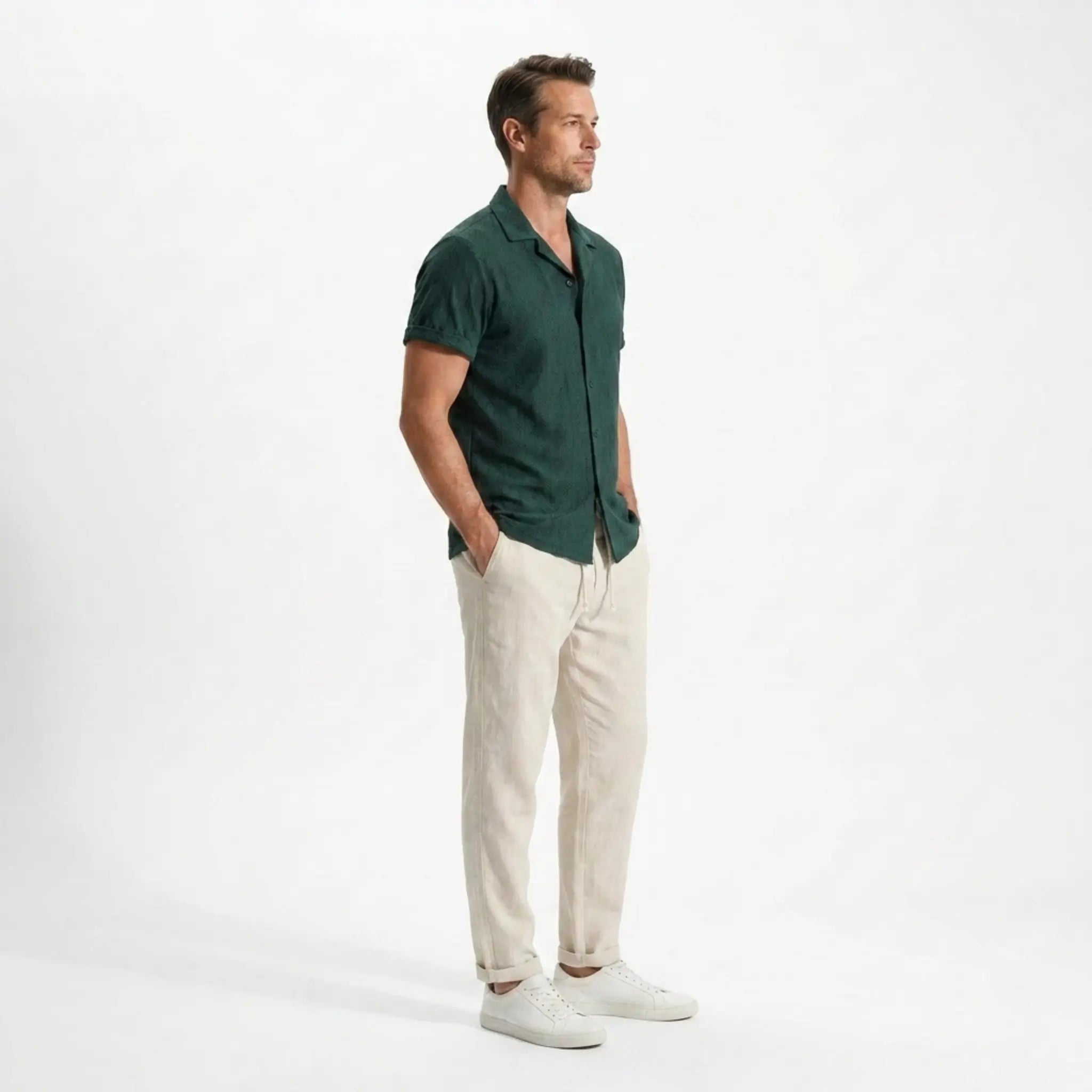 Man wearing a green polo shirt and beige pants side view on a white background