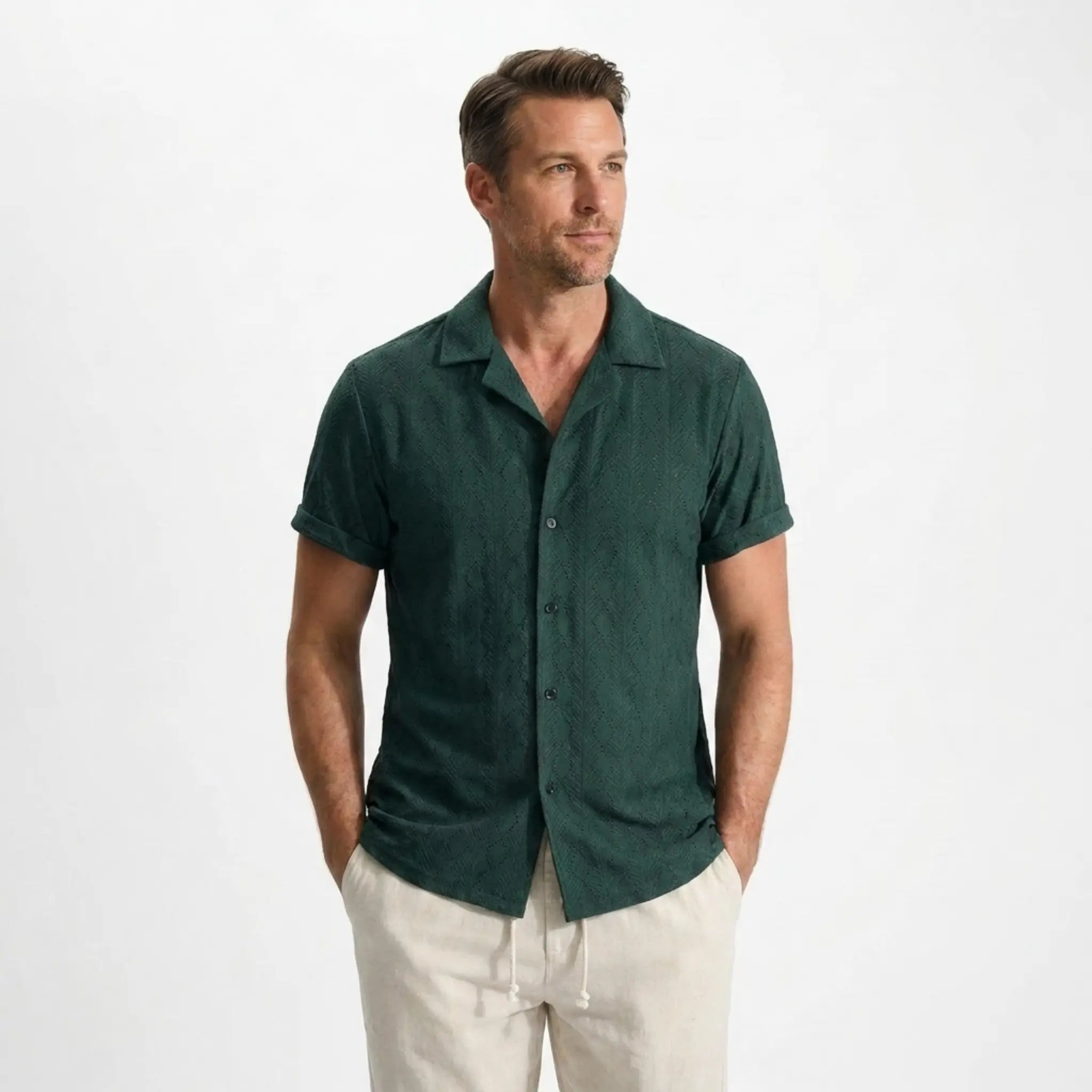 Man wearing a green shirt and beige pants on a white background