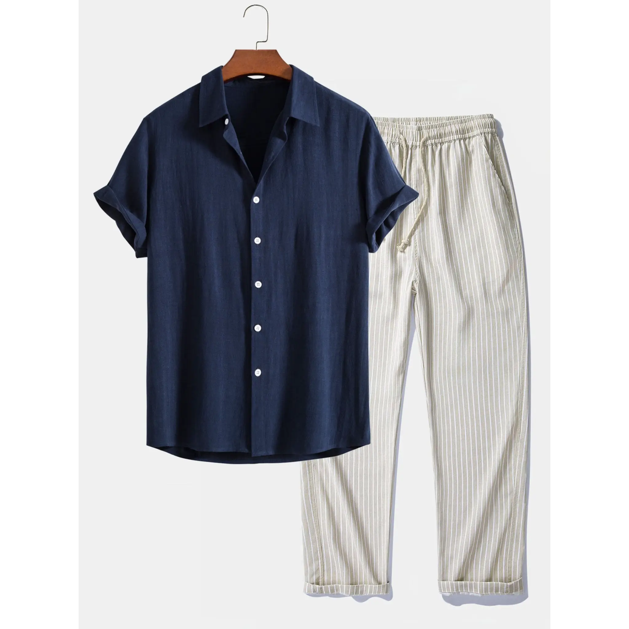 Navy shirt and beige striped pants on a hanger against a white background
