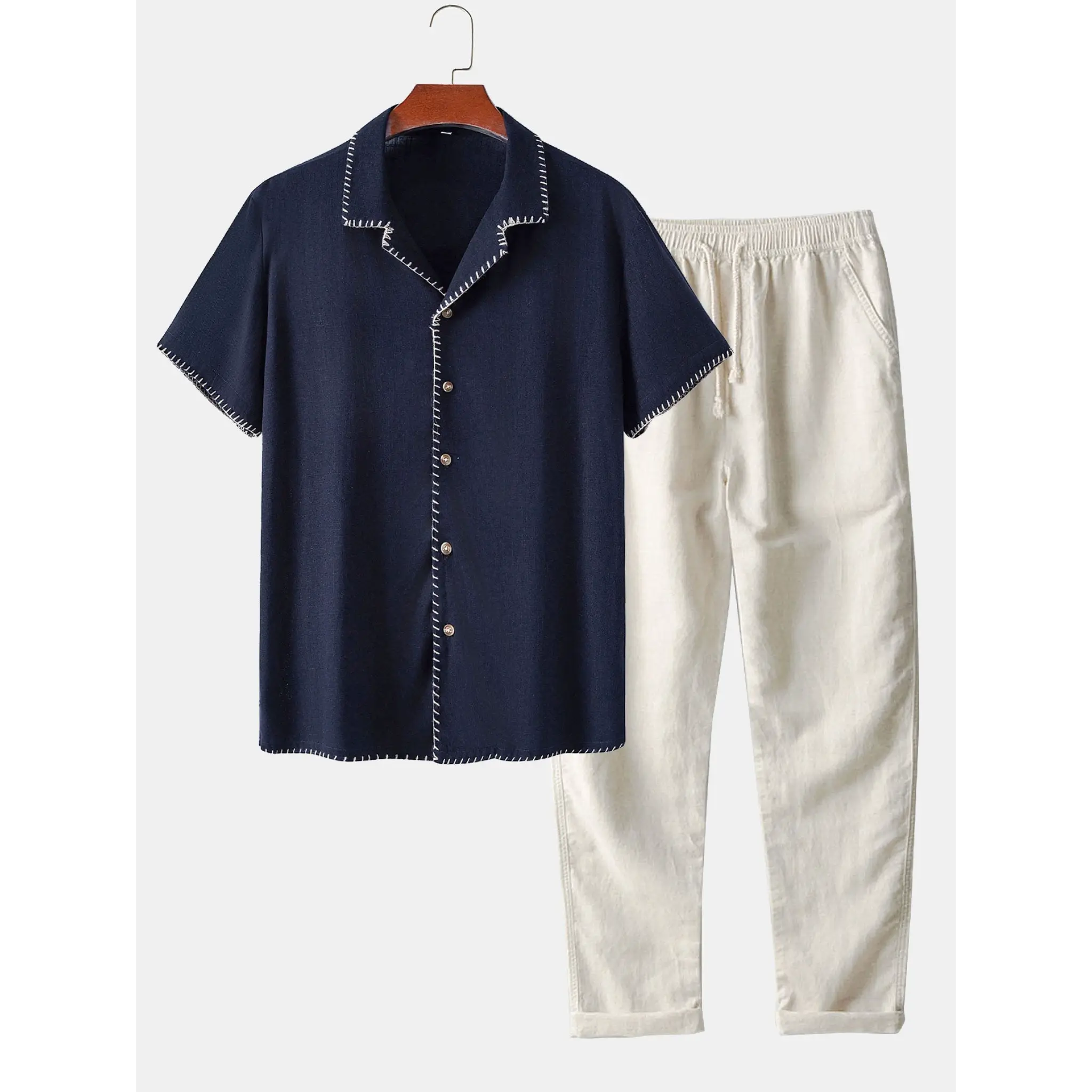 Navy shirt and beige pants on a hanger against a white background