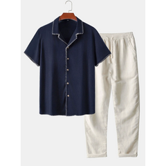 Navy shirt and beige pants on a hanger against a white background