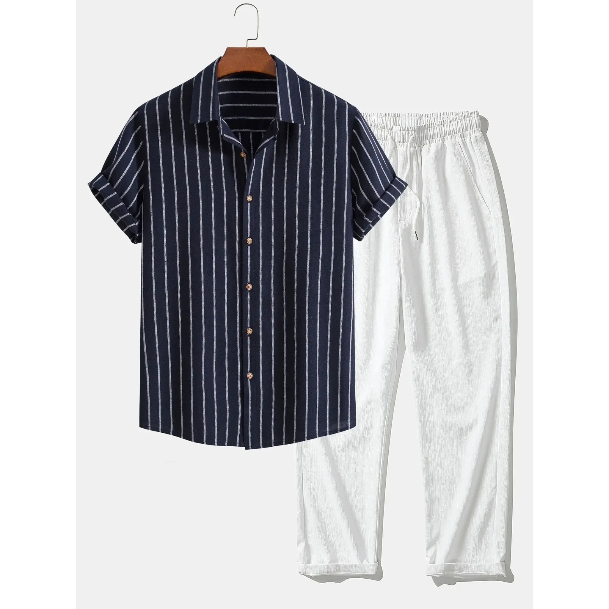 Navy striped shirt and white pants on a hanger against a white background