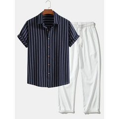 Navy striped shirt and white pants on a hanger against a white background