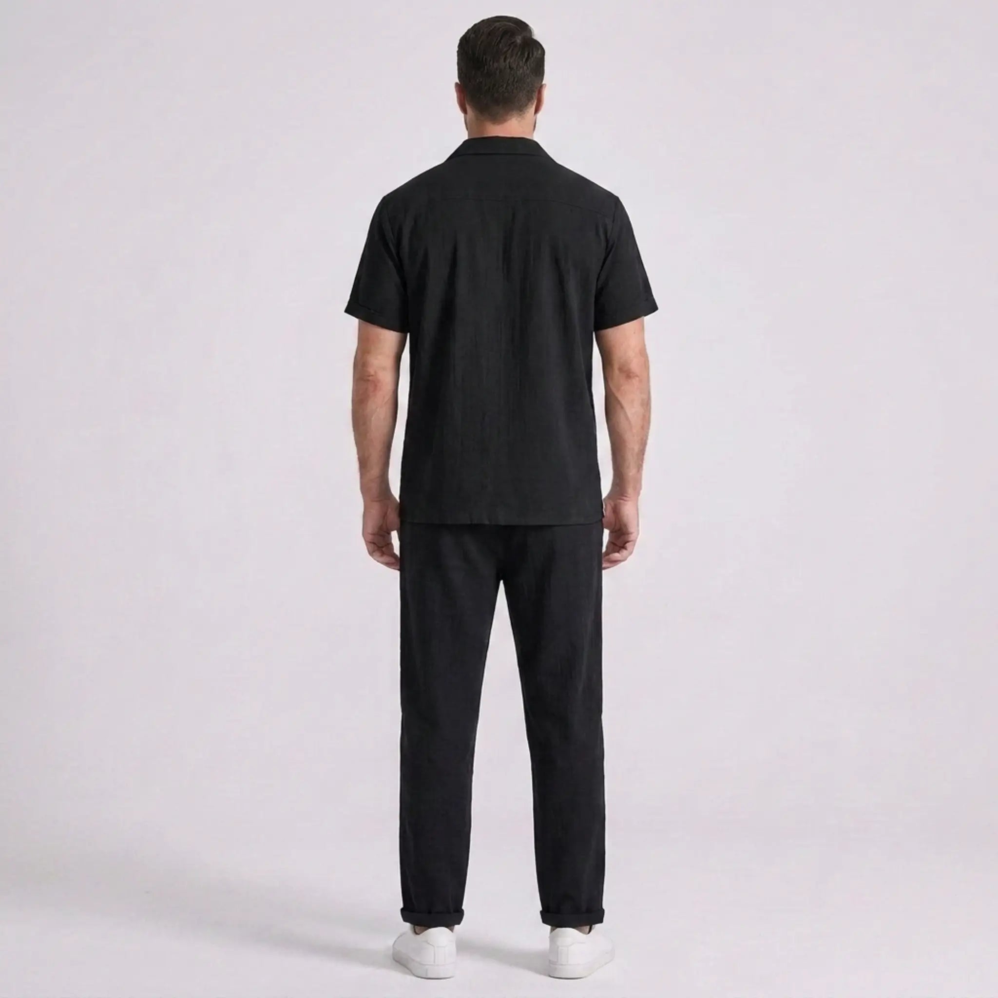 Person wearing a black outfit on a white background