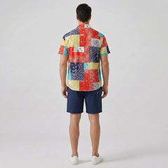 Person wearing a colorful patchwork shirt and navy shorts back view on a white background