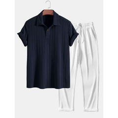 Black shirt and white pants on a hanger against a white background