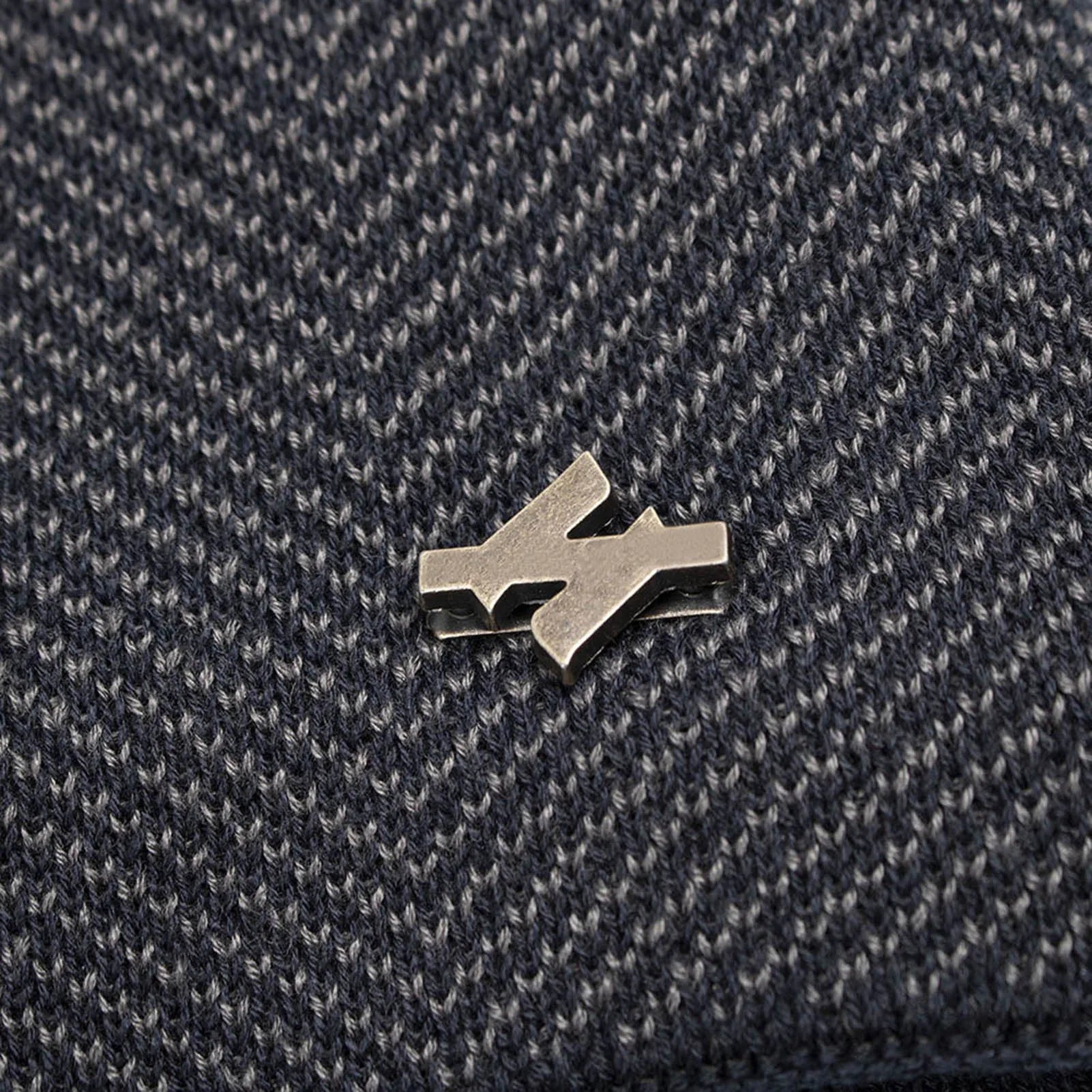 Close-up of the beanie's fine knit texture and metal badge