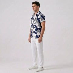 Side view of man wearing a patterned shirt and white pants on a plain background