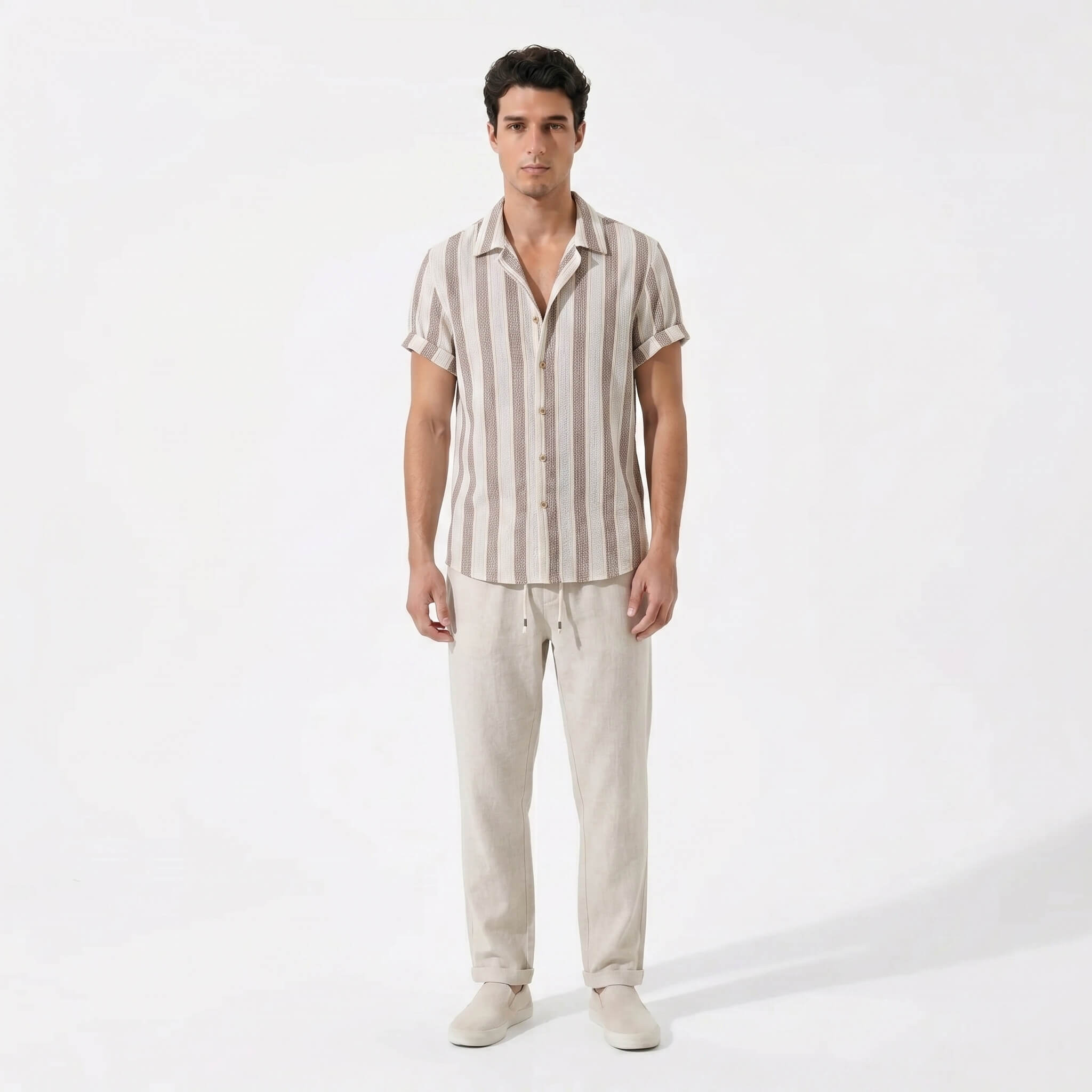 Man wearing a striped shirt and beige pants on a white background