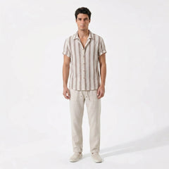 Man wearing a striped shirt and beige pants on a white background