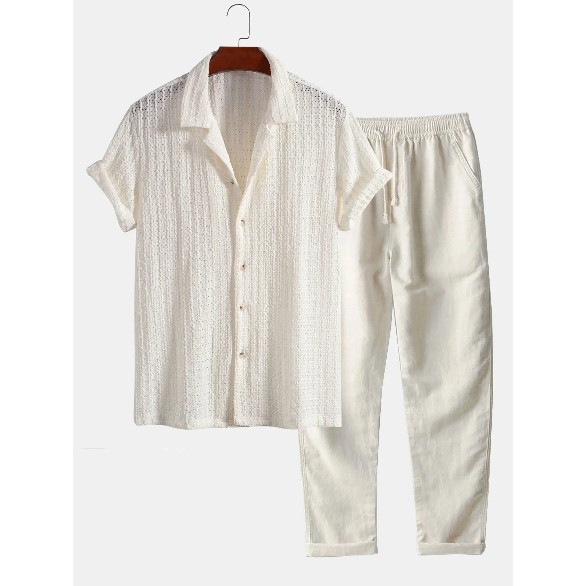 White cream short-sleeve shirt and pants set on a hanger against a white background