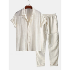 White cream short-sleeve shirt and pants set on a hanger against a white background