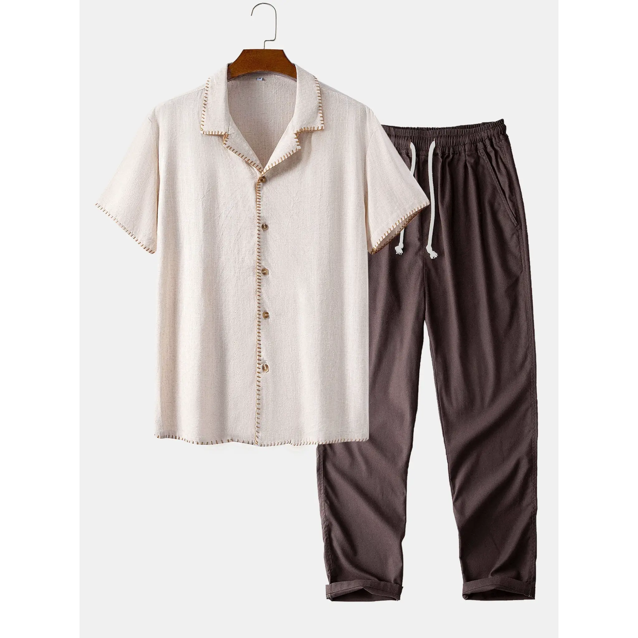 White shirt with buttons and brown pants on a hanger against a white background