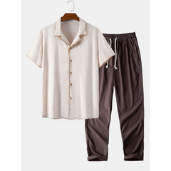 White shirt with buttons and brown pants on a hanger against a white background