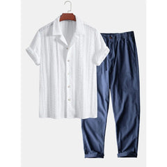 White short-sleeve shirt and blue pants on a hanger against a white background