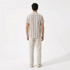 back view of man wearing a striped shirt and beige pants on a white background