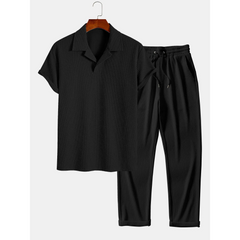 black polo and trouser on a hanger on white background