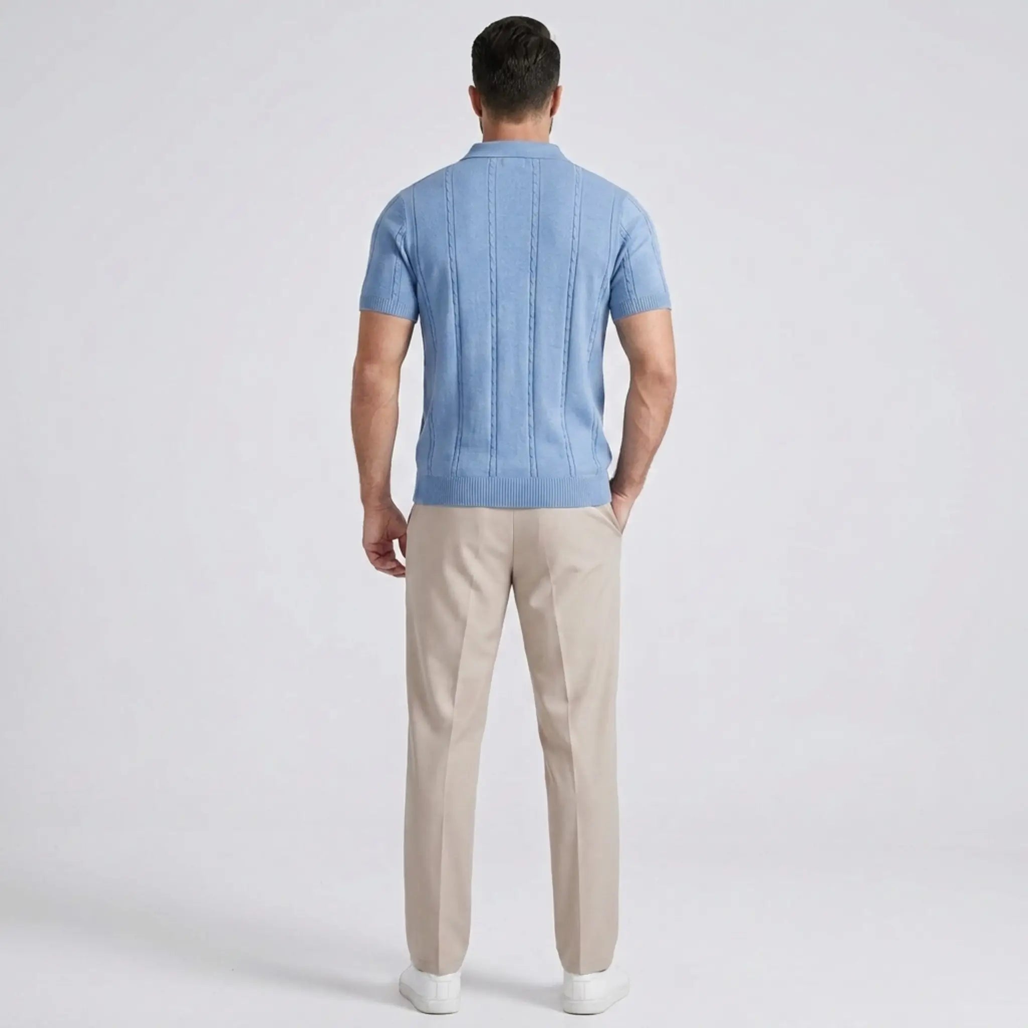 Back view of Man wearing a sky blue shirt with beige pants on a gray background