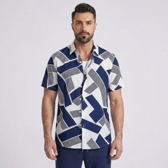 Man wearing a blue and white geometric patterned shirt on a light gray background
