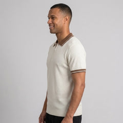 Man wearing apricot color block knit polo shirt in outdoor lifestyle setting