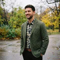 MannerCo army green washed cotton casual blazer jacket worn outdoors in autumn park setting