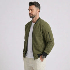 Man wearing MannerCo army green quilted zip-up baseball jacket with stand collar, side view