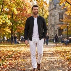 Man wearing MannerCo black quilted zip-up baseball jacket in outdoor lifestyle setting