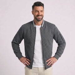 Man wearing MannerCo dark gray quilted zip-up baseball jacket with stand collar, front view