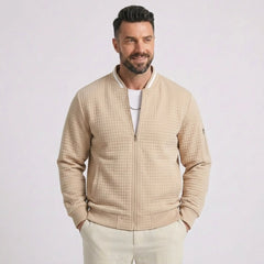 Man wearing MannerCo khaki quilted zip-up baseball jacket with stand collar, front view