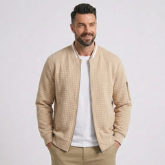 Man wearing MannerCo khaki quilted zip-up baseball jacket with stand collar, front view