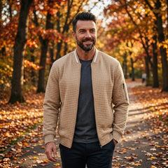 Man wearing MannerCo khaki quilted zip-up baseball jacket in outdoor lifestyle setting
