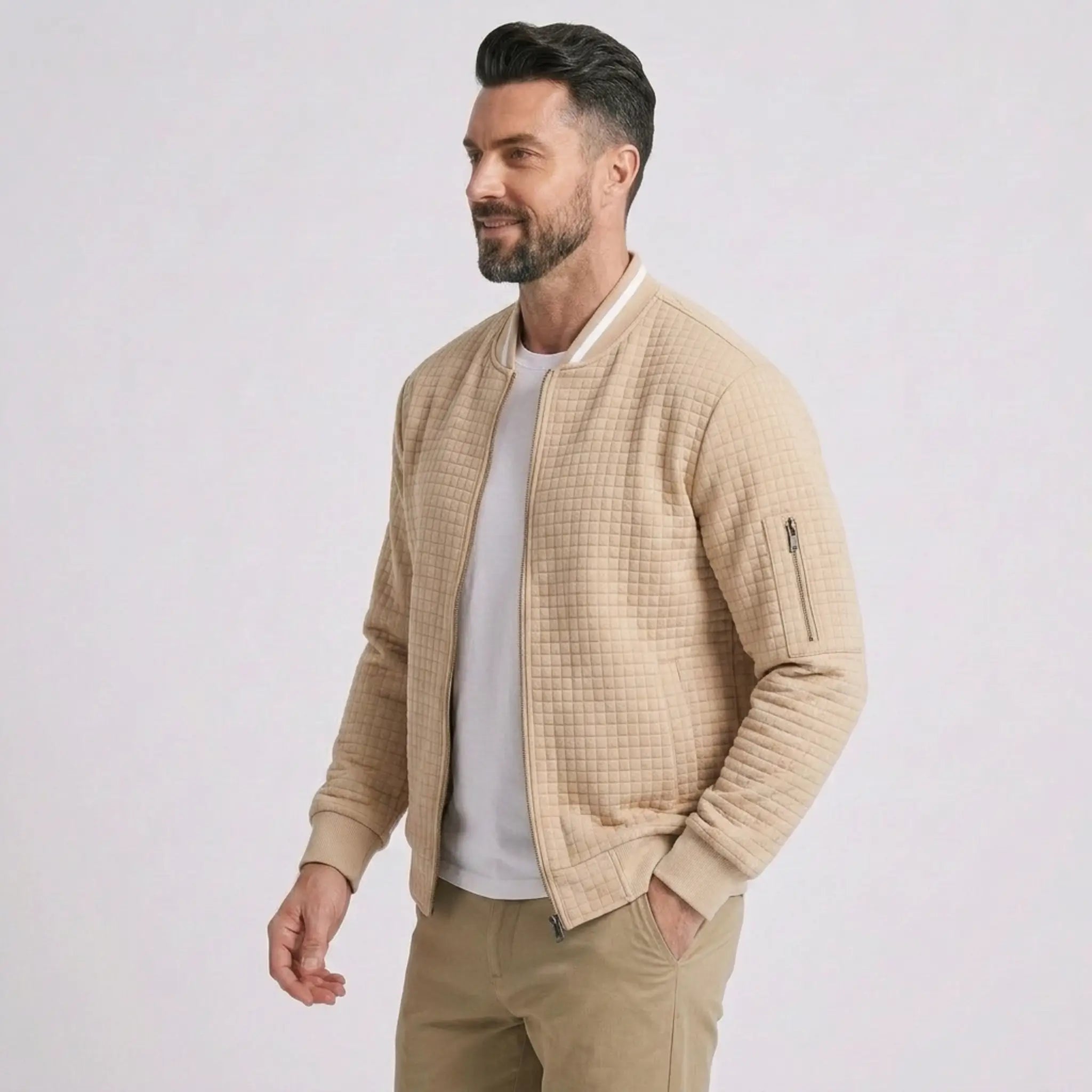 Man wearing MannerCo khaki quilted zip-up baseball jacket with stand collar, side view