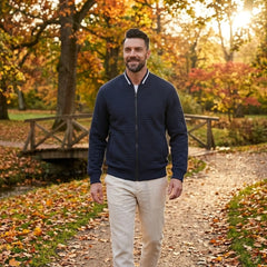 Man wearing MannerCo navy quilted zip-up baseball jacket in outdoor lifestyle setting