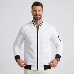 Man wearing MannerCo white quilted zip-up baseball jacket with black ribbed collar and cuffs, front view