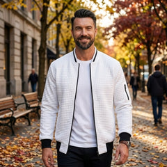Man wearing MannerCo white quilted zip-up baseball jacket in outdoor lifestyle setting