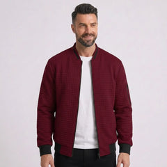 Man wearing MannerCo wine red quilted zip-up baseball jacket with stand collar, front view