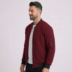 Man wearing MannerCo wine red quilted zip-up baseball jacket with stand collar, side view